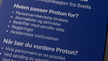 Et nærbilde av en fysisk Proton-plakat med fokus på personvern, fotografert i skrå vinkel med profesjonell belysning, tydelig logo og punkterte lister over hvem Proton passer for og når det bør vurderes.