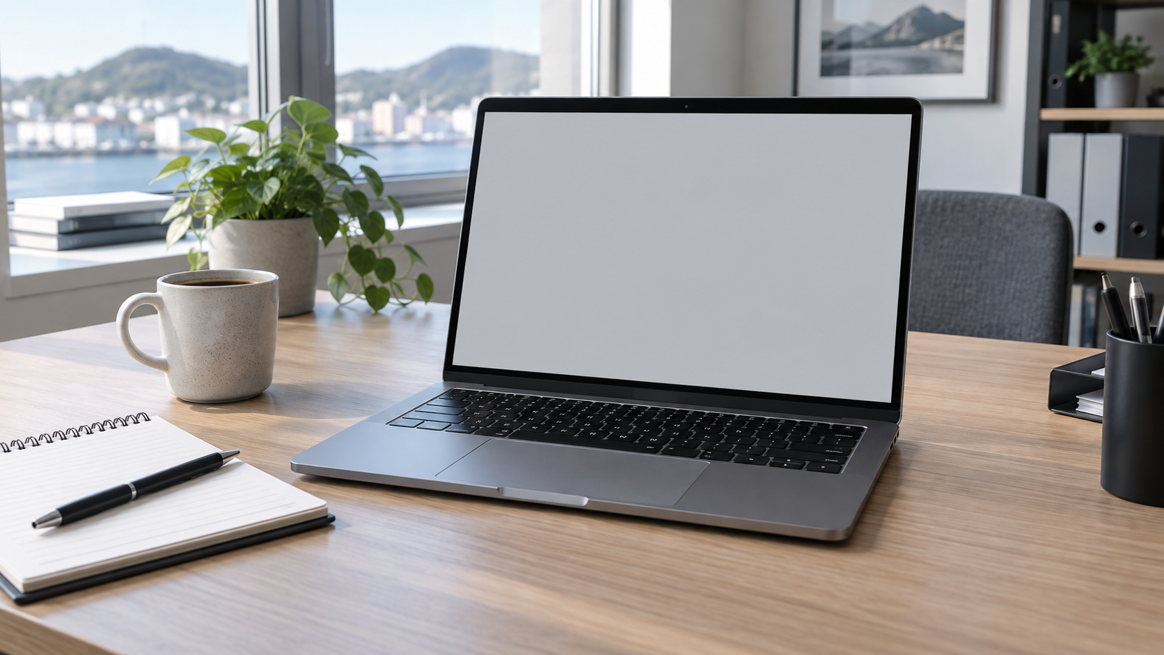 Bærbar PC med blank skjerm og notatbok på et skrivebord